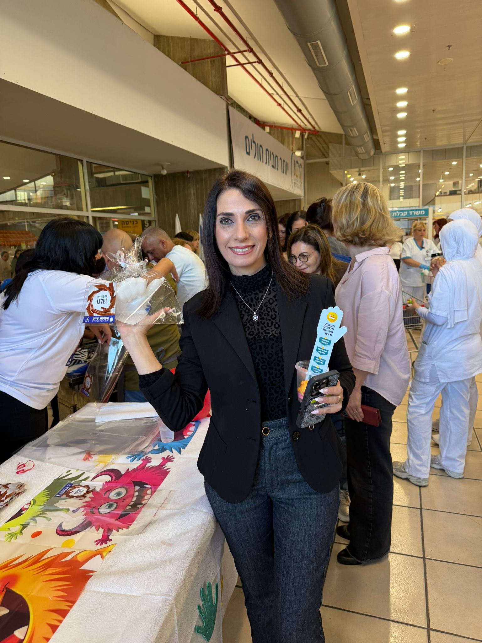 עובדת עם פסלון יד שעווה וקופסת מתנה ממותגת