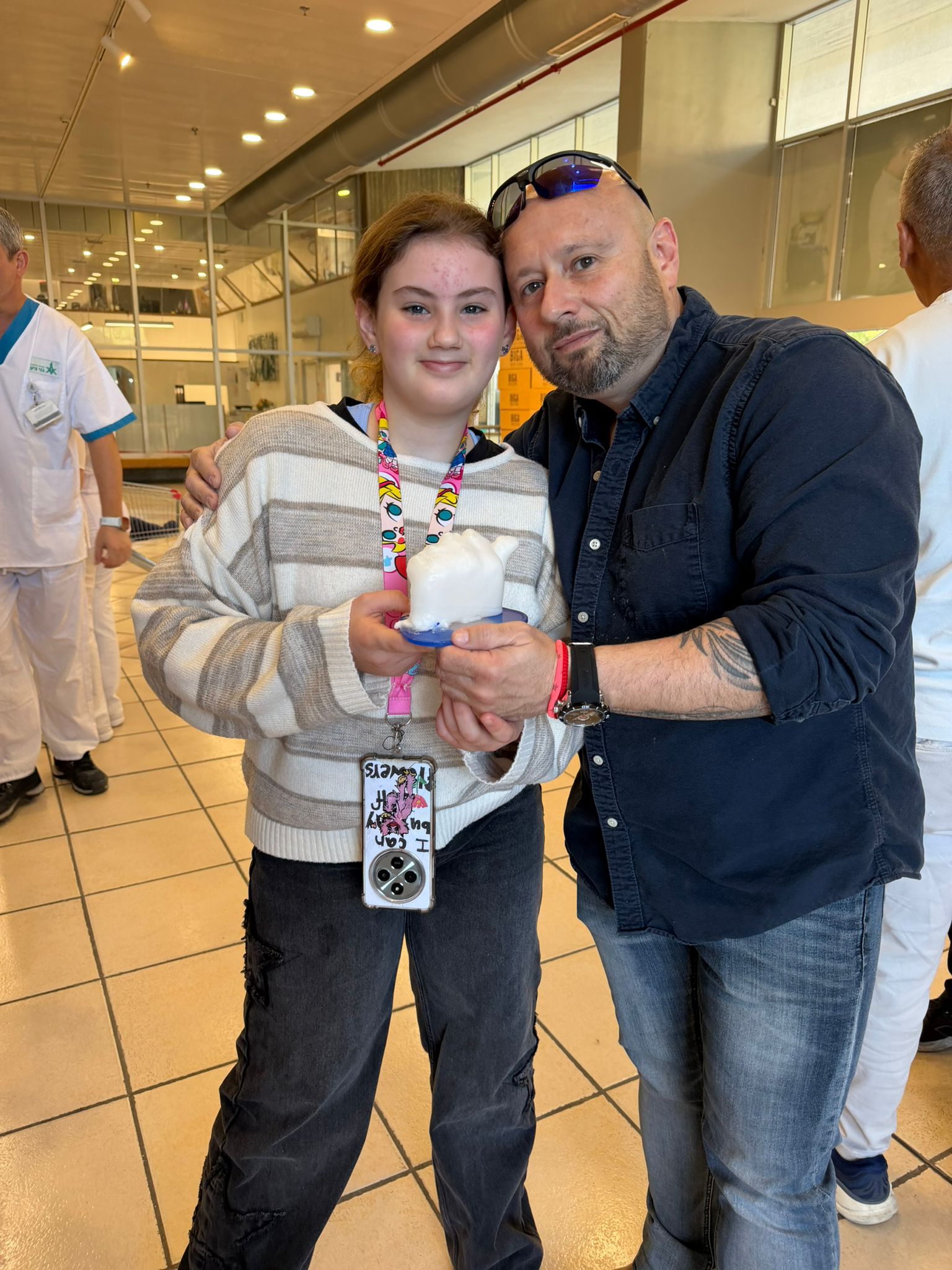 מושיקו עם משתתפת שמציגה פסלון יד שעווה צבעוני