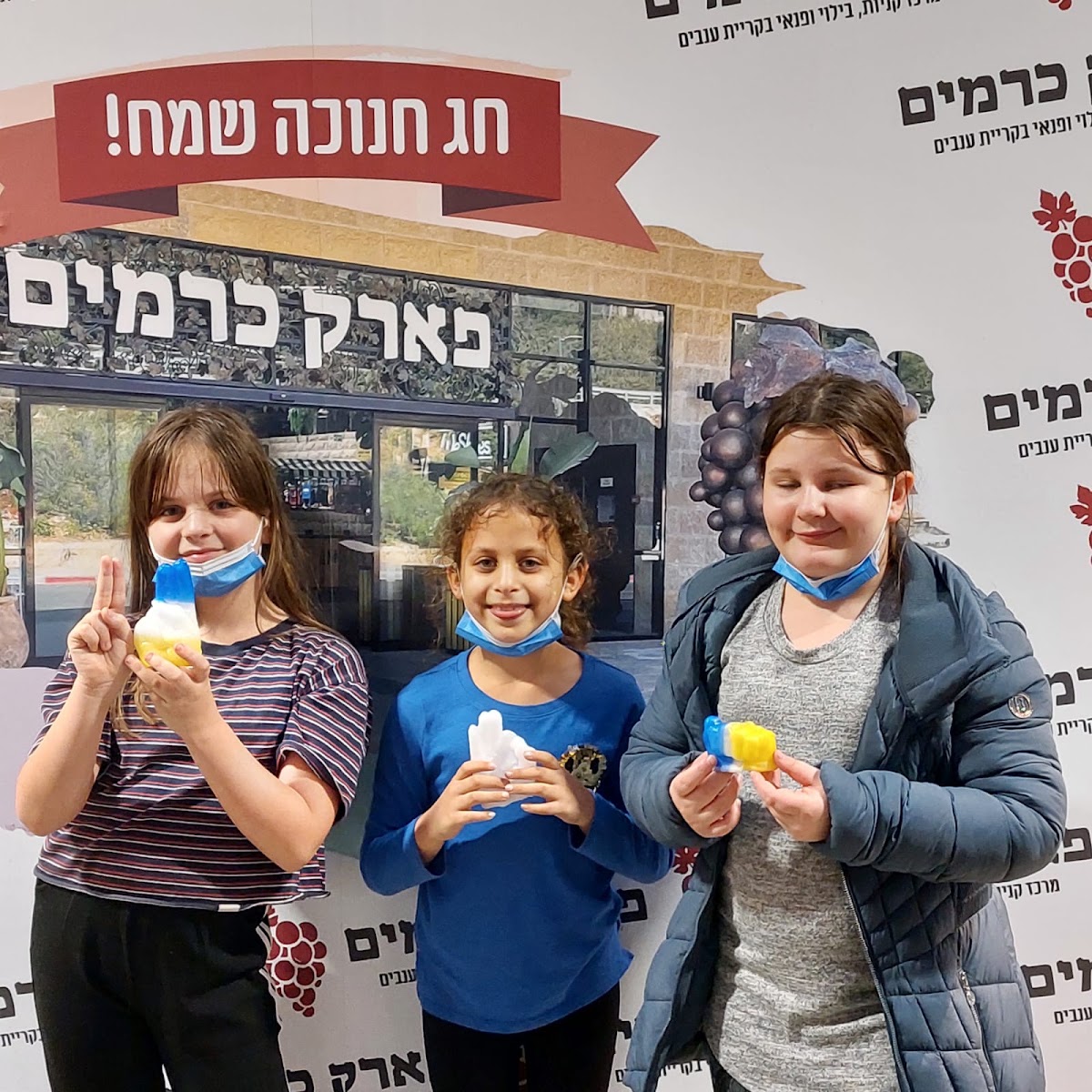 שלושה ילדים עם ידי שעווה באירוע חנוכה