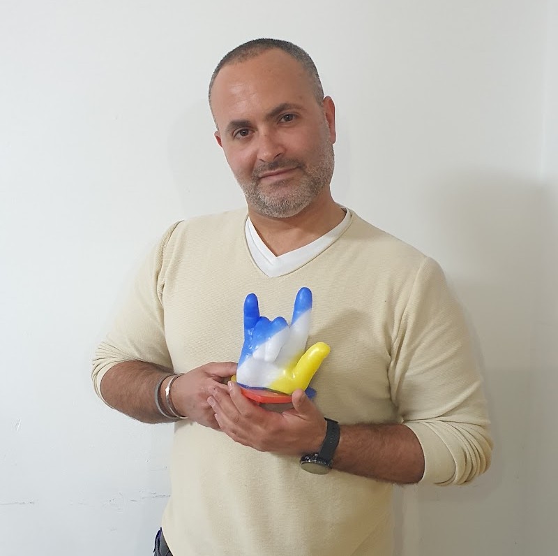 אורח מבוגר מחזיק פסלון יד שעווה צבעוני